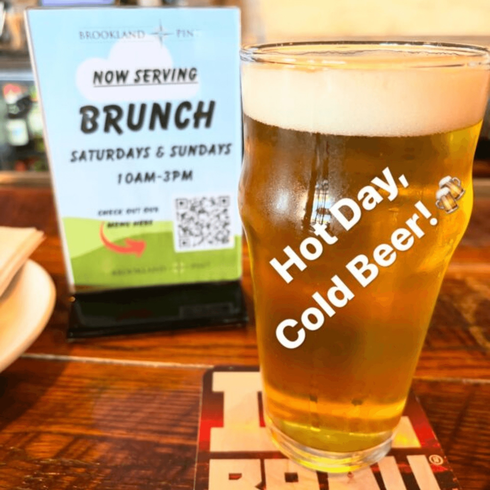 A pint of beer with "Hot Day, Cold Beer!" text next to a Brookland Pint brunch sign.